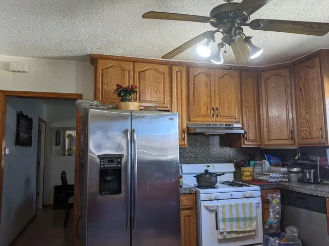 a kitchen with stainless steel appliances granite countertop a sink a stove and cabinets