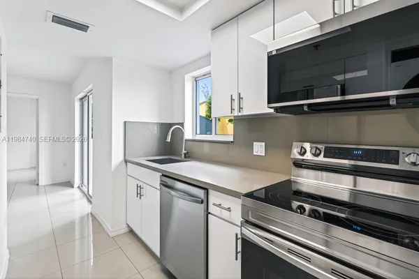 a kitchen with stainless steel appliances kitchen island a stove and a microwave