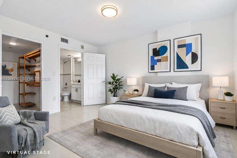 2475 Northwest 16th St Road, Unit 211 Miami, FL 33125 - Photo 17 of 29 a bedroom with a large bed couch and lots of painting on the wall