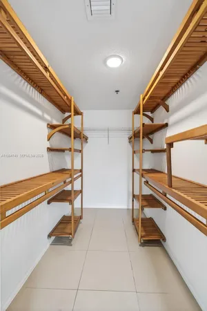 a bathroom with a white bath tub a toilet and a large mirror