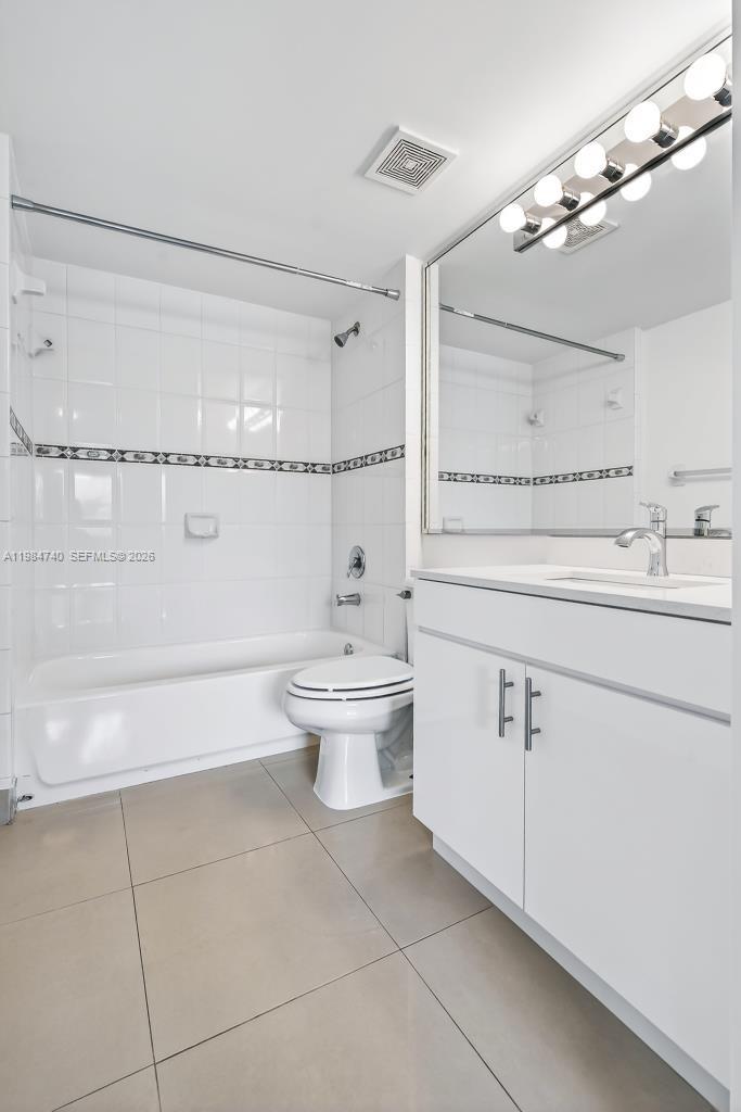 2475 Northwest 16th St Road, Unit 211 Miami, FL 33125 - Photo 19 of 29 a bathroom with a white bath tub a toilet and a large mirror