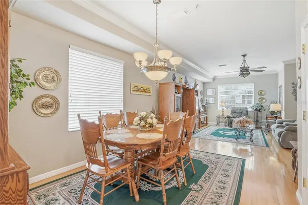 a kitchen with stainless steel appliances granite countertop a stove top oven a sink a dining table and chairs with white cabinets