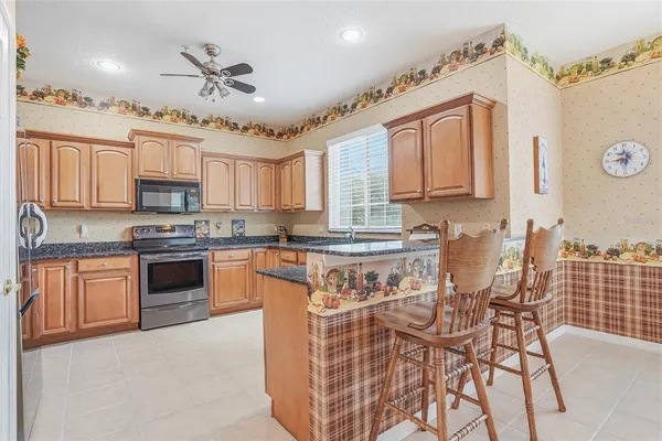a kitchen with granite countertop a refrigerator stove top oven and sink