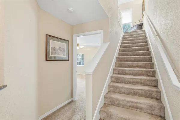 a view of staircase with wooden floor and white walls
