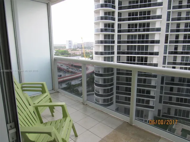 a view of balcony with a couple of cars parked in front of it