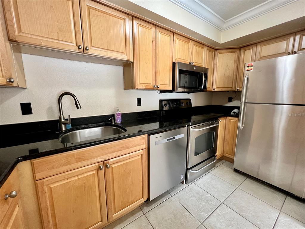 631 North Orange Avenue, Unit 201 Sarasota, FL 34236 - Photo 2 of 14 a kitchen with granite countertop a refrigerator stove and sink