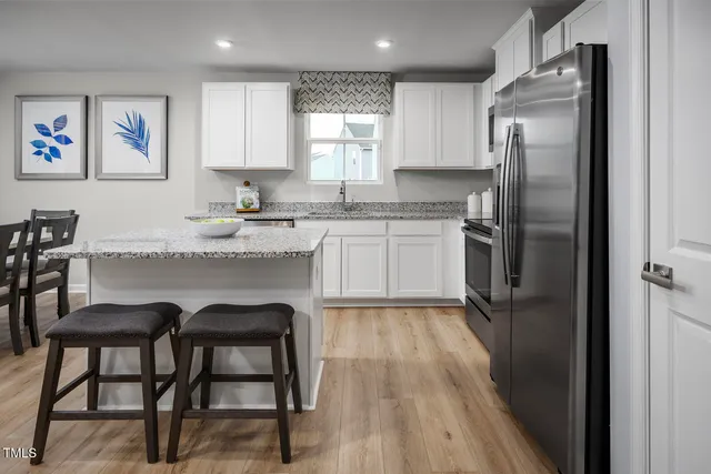 a kitchen with a refrigerator a stove a sink and cabinets