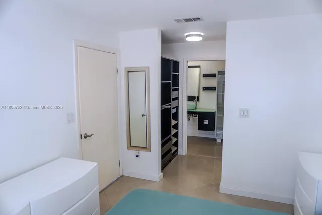 a view of a hallway with bathroom and a bathroom