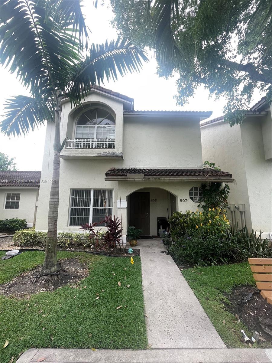 805 Northwest 108th Terrace, Unit 7L5 Pembroke Pines, FL 33026 - Photo 5 of 28 a front view of a house with a garden and palm tree
