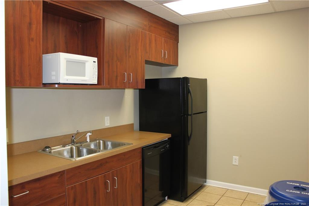 3709 Raeford Road Fayetteville, NC 28304 - Photo 30 of 44 a kitchen with a refrigerator and cabinets