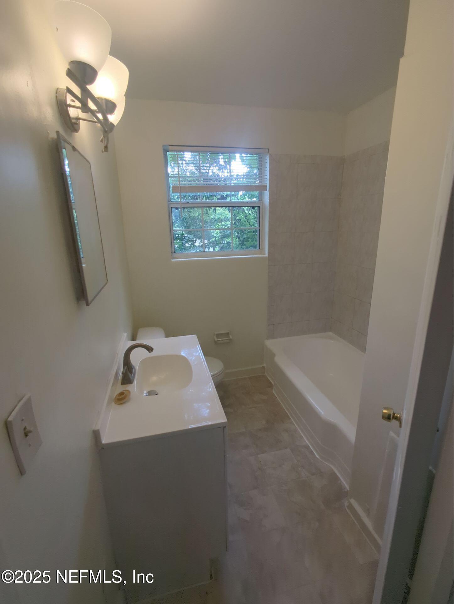 3136 Post Street Jacksonville, FL 32205 - Photo 13 of 16 a bathroom with a bathtub sink and mirror
