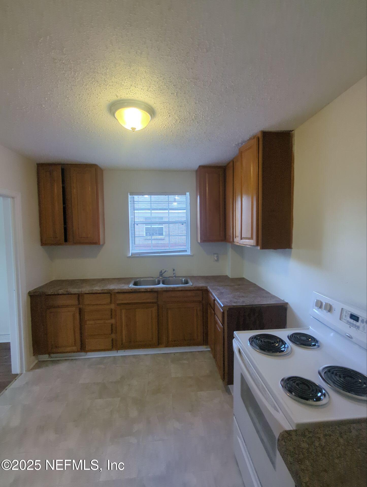 3136 Post Street Jacksonville, FL 32205 - Photo 8 of 16 a kitchen with a stove a sink and a refrigerator