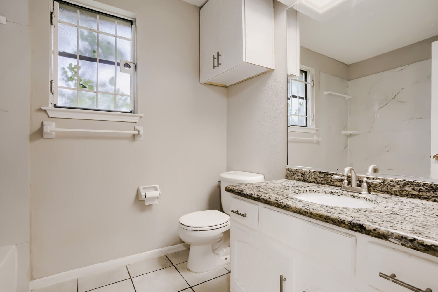 10103 Inwood Shadows Street Houston, TX 77088 - Photo 24 of 32 a bathroom with a granite countertop sink a toilet and a window