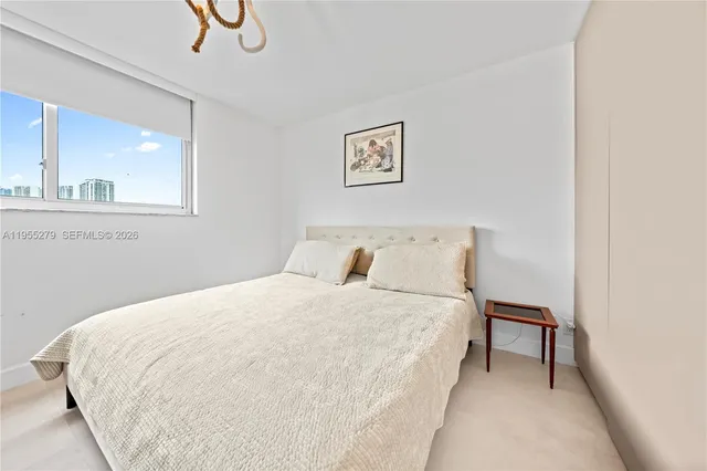 a large bed sitting in a bedroom next to a window