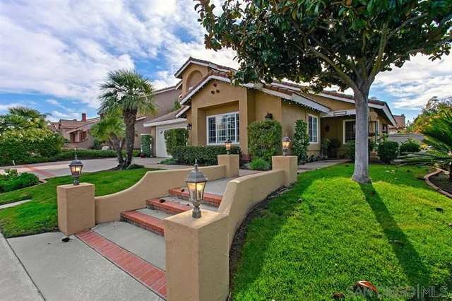 a front view of a house with yard and green space