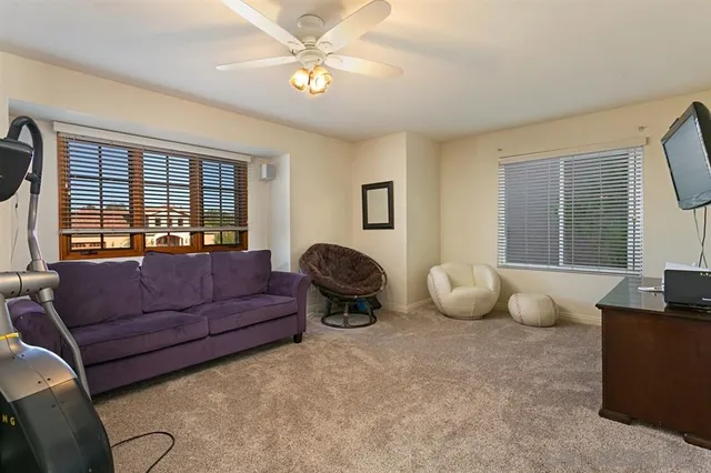 a living room with furniture ceiling fan and a window