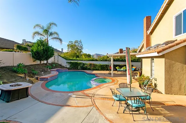 a view of a swimming pool with a chairs and table in a patio