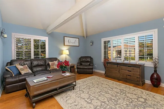 a living room with furniture a couch and large windows