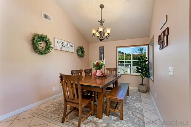 a view of a dining room with furniture a chandelier and window
