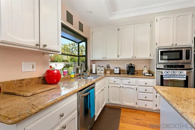 a kitchen with stainless steel appliances granite countertop a sink and cabinets