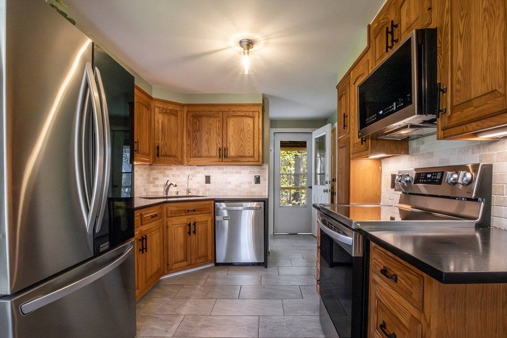 196 Center Street Groveland, MA 01834 - Photo 9 of 32 a kitchen with stainless steel appliances granite countertop a refrigerator stove and sink