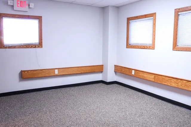 an empty room and a bathroom with windows