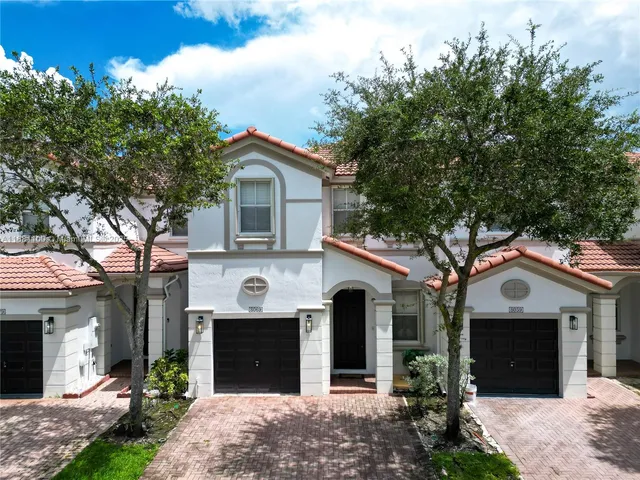 a front view of a house with a garden and garage