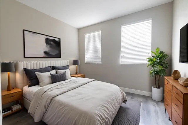 a bedroom with bed plant and window