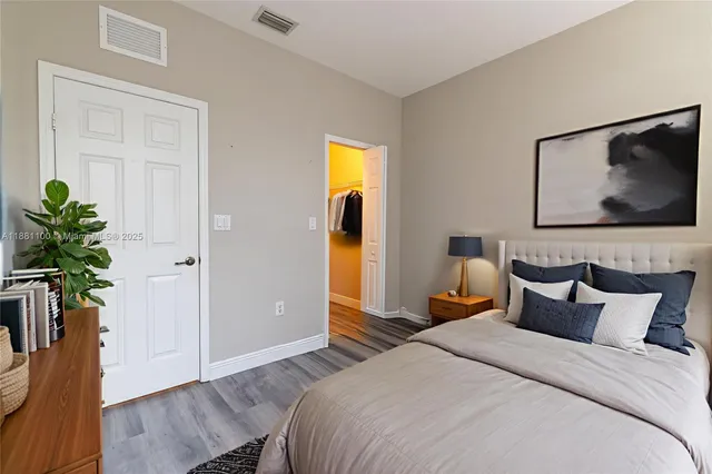 a bedroom with bed and wooden floor