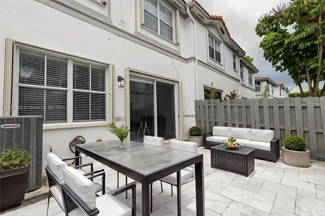 a view of a patio with table and chairs and potted plants