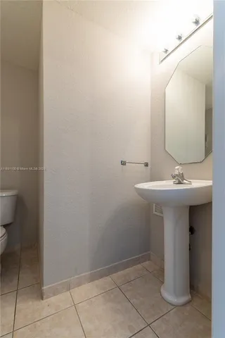a bathroom with a sink toilet and mirror