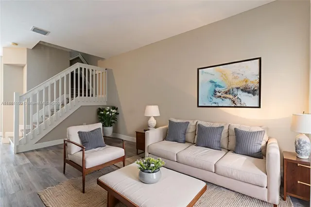 a living room with furniture a rug and a window