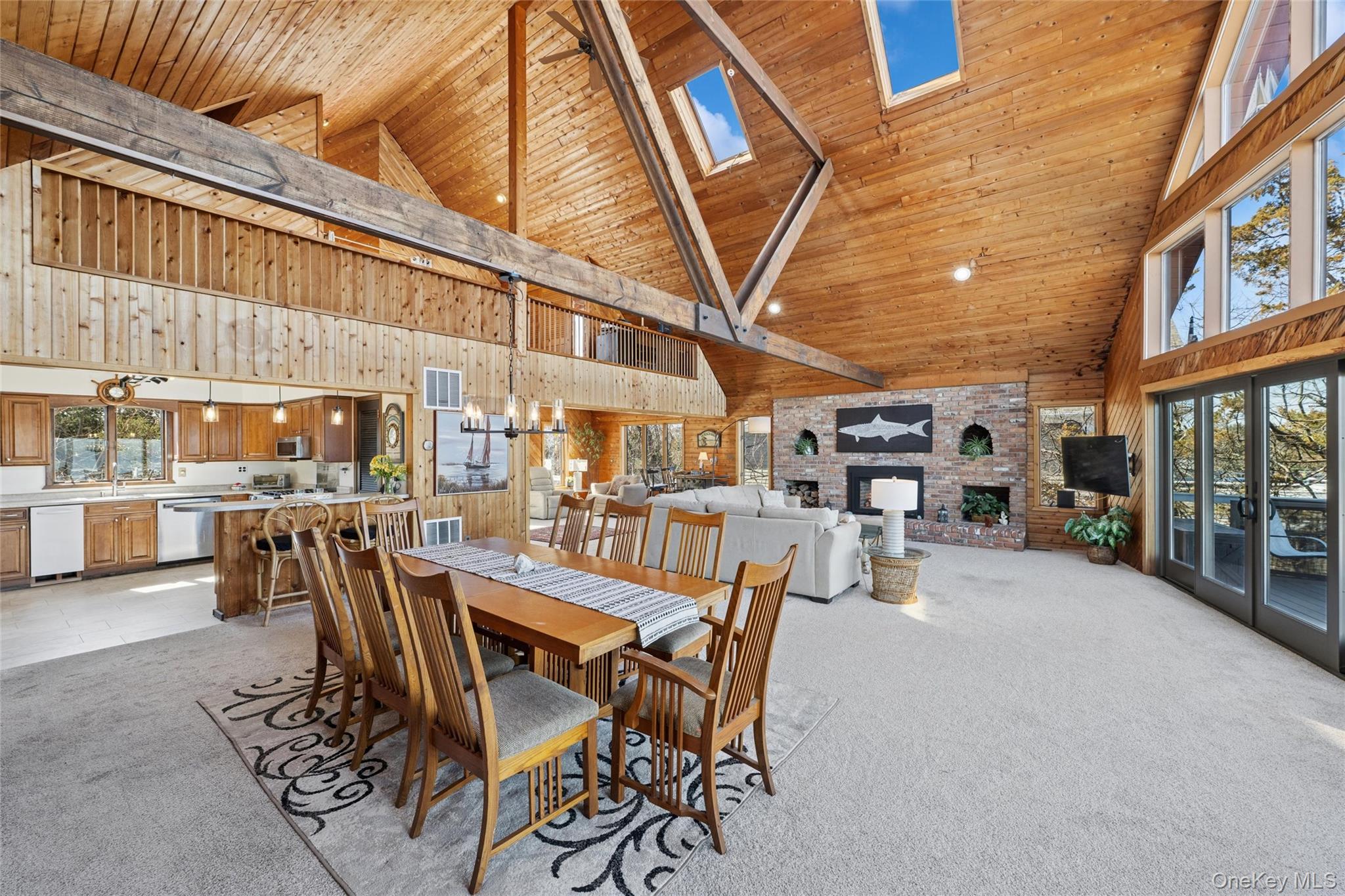 171 Harbor Beach Road Mount Sinai, NY 11766 - Photo 10 of 46 Open concept main floor features kitchen with breakfast bar, dining area, living room with gas fireplace, magnificent water views & lounge area to back deck