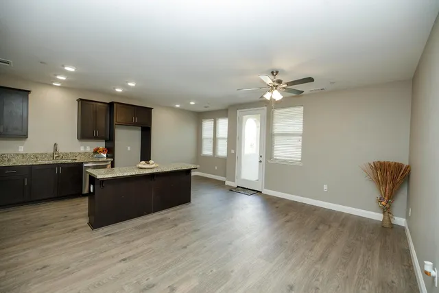a large kitchen with stainless steel appliances granite countertop a sink counter space and a large window