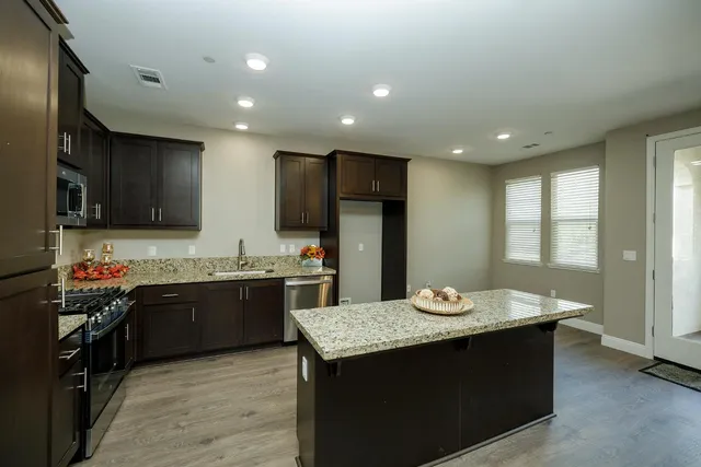 a kitchen with kitchen island granite countertop stainless steel appliances lots of counter top space