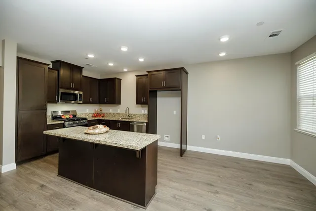 a kitchen with stainless steel appliances granite countertop a sink stove and refrigerator