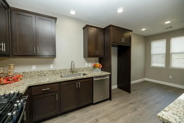 a kitchen with granite countertop wooden cabinets and stainless steel appliances