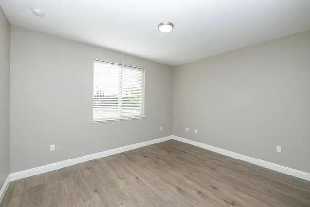 wooden floor in an empty room with a window