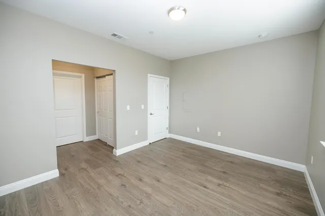 a view of an empty room with wooden floor