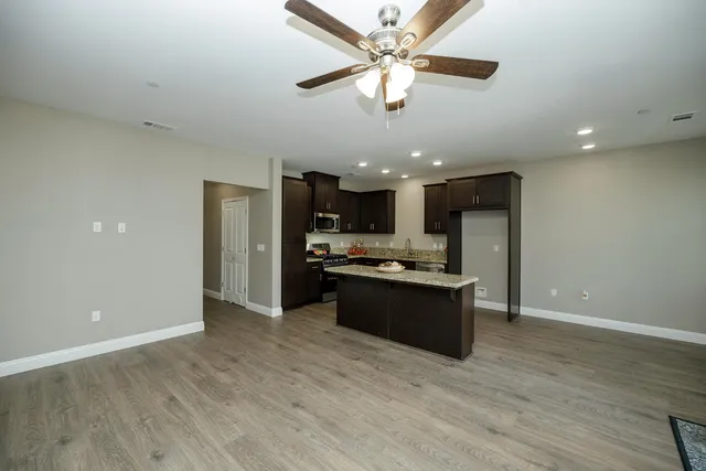a large kitchen with a large counter space a sink and stainless steel appliances
