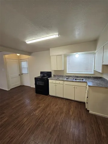a large kitchen with kitchen island wooden floors and stainless steel appliances
