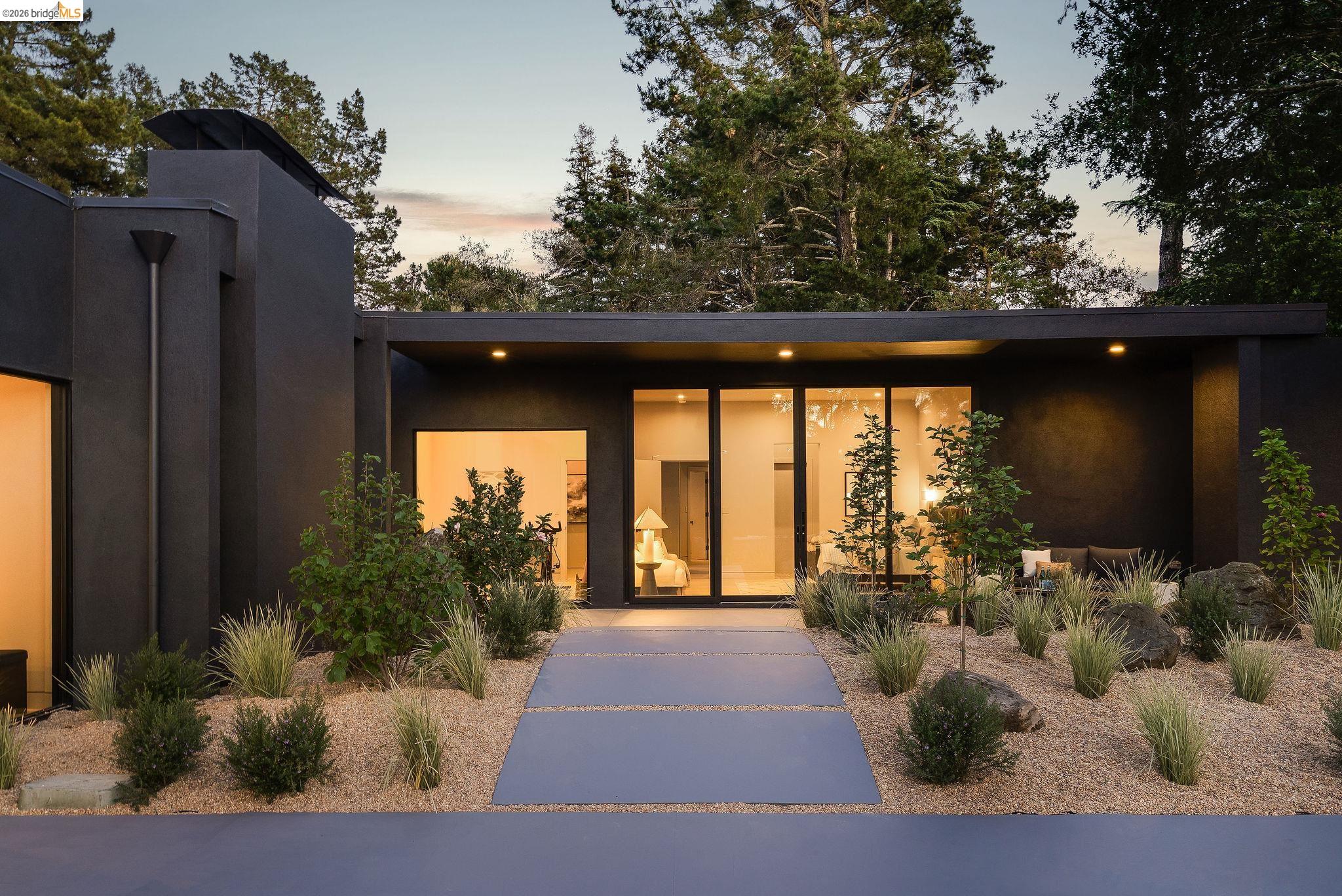 5645 Bacon Road Oakland, CA 94619 - Photo 74 of 94 Modern single-story exterior with dark stucco finish, flat roofline, and integrated solar panels
