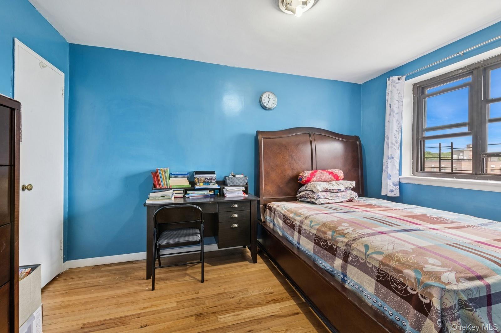 87-30 204th Street, Unit A78 Queens, NY 11423 - Photo 9 of 14 a bedroom with a bed and a table
