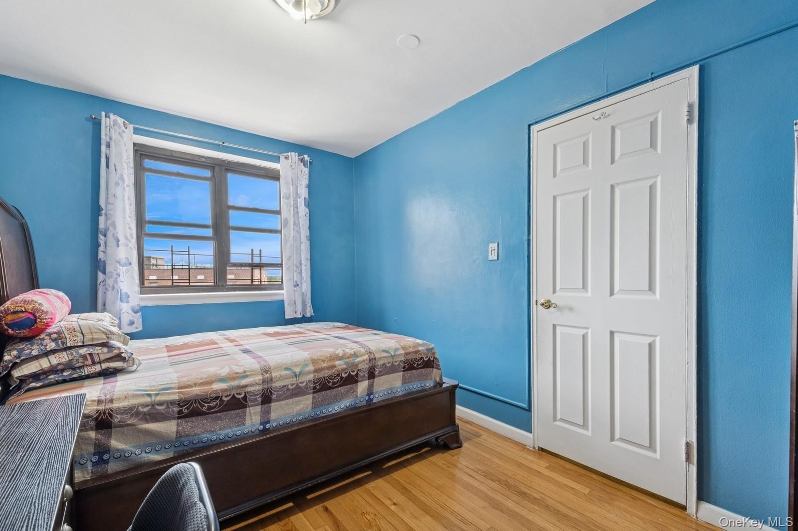 87-30 204th Street, Unit A78 Queens, NY 11423 - Photo 10 of 14 a bedroom with a bed next to a window