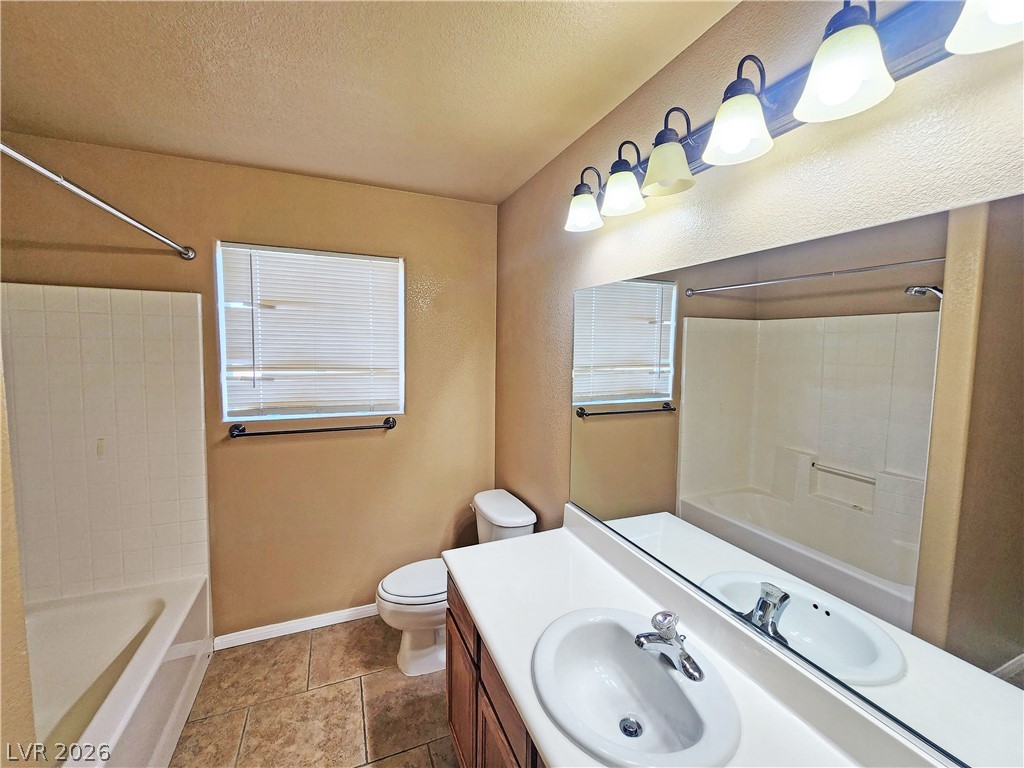 3680 Ravine Avenue Pahrump, NV 89048 - Photo 21 of 28 Full bath featuring vanity, a textured ceiling, toilet, baseboards, and washtub / shower combination
