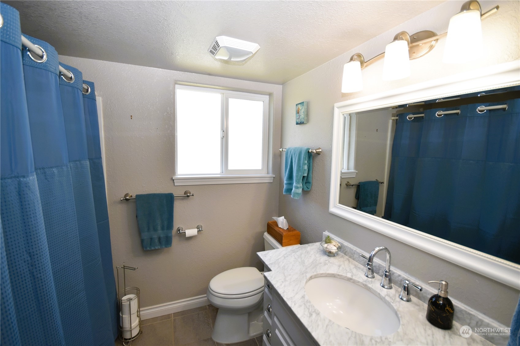 8124 East Daniels Loop Port Orchard, WA 98366 - Photo 15 of 24 a bathroom with a sink toilet a mirror and shower