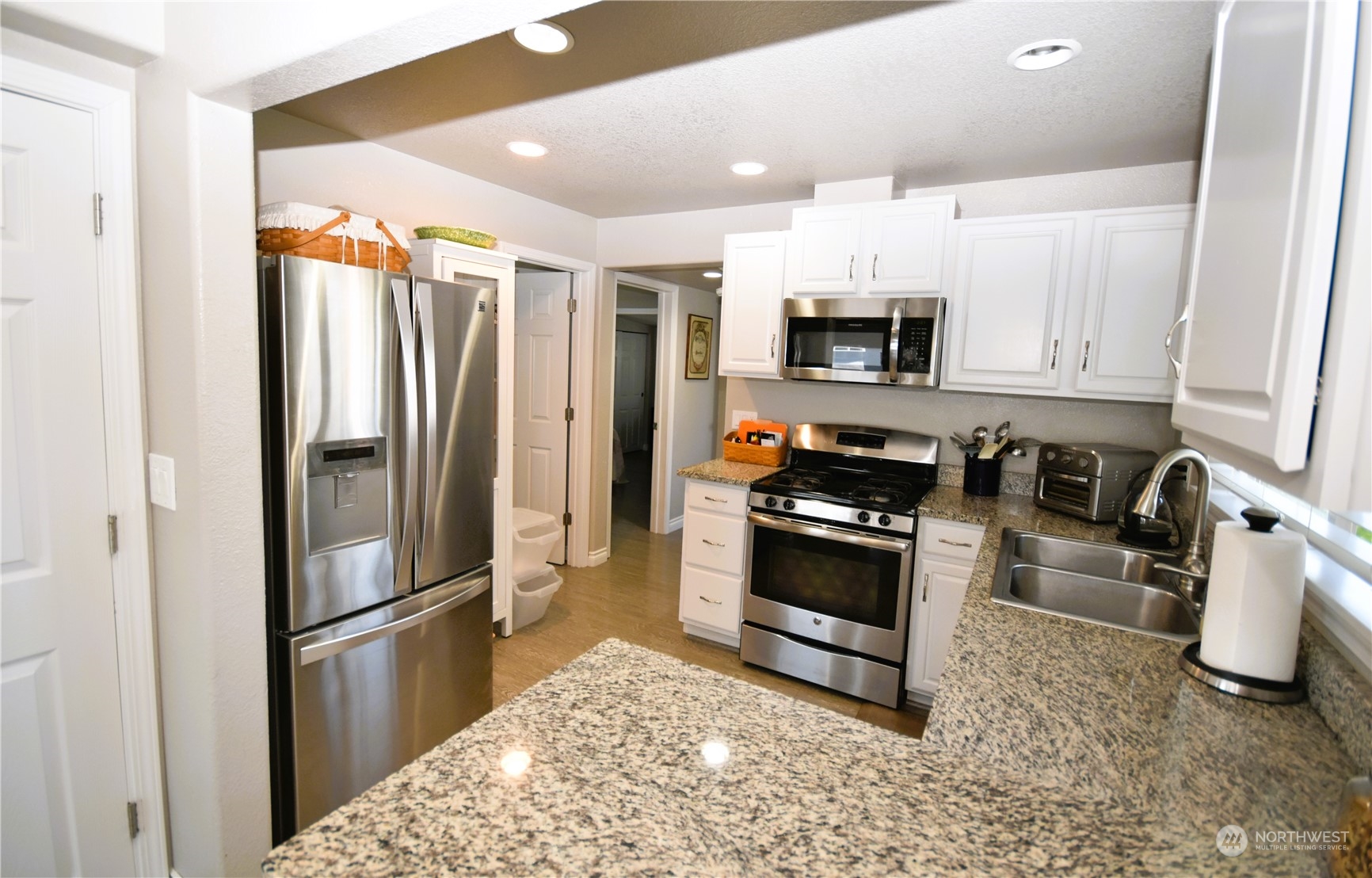 8124 East Daniels Loop Port Orchard, WA 98366 - Photo 8 of 24 a kitchen with granite countertop a refrigerator and a stove top oven