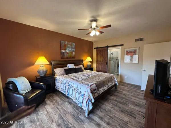 a bedroom with a bed and wooden floor
