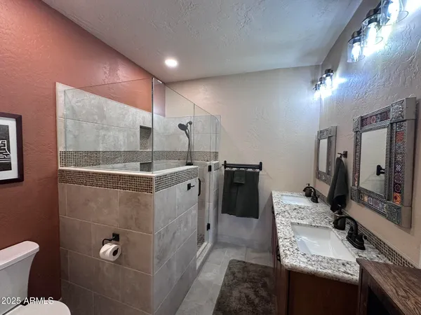a bathroom with a sink toilet double vanity and mirror