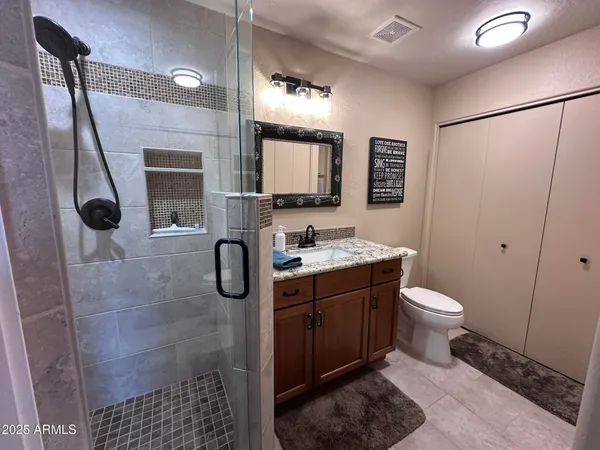 a bathroom with a granite countertop sink toilet and shower